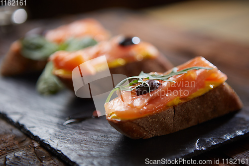 Image of The tasty bruschetta with salmon on black stone