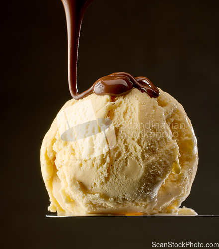 Image of melted chocolate pouring on vanilla ice cream