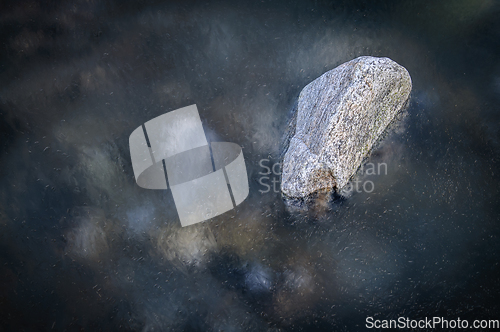 Image of stone in river with ice