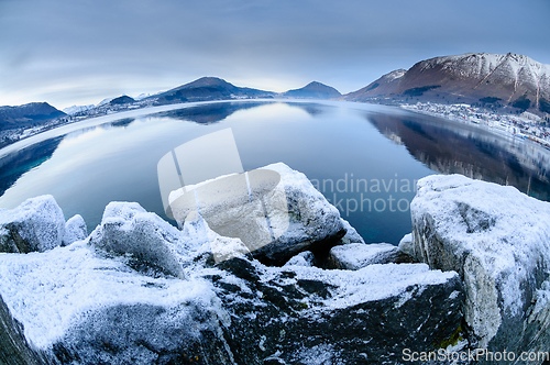 Image of snow covered mountains and rocks my the sea