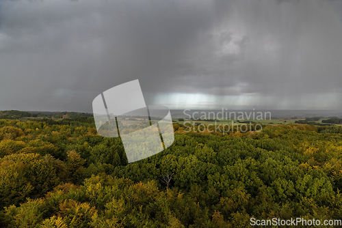 Image of Rain clouds and rain over autumn landscape