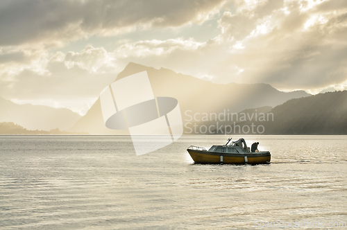 Image of angler in a boat among mountains