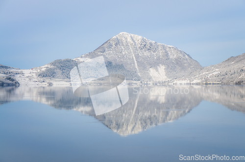 Image of reflection of snowcovered mountain by the ocean