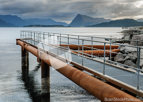 Image of pier on the coast with mountains