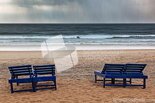 Image of Beach chairs under rain