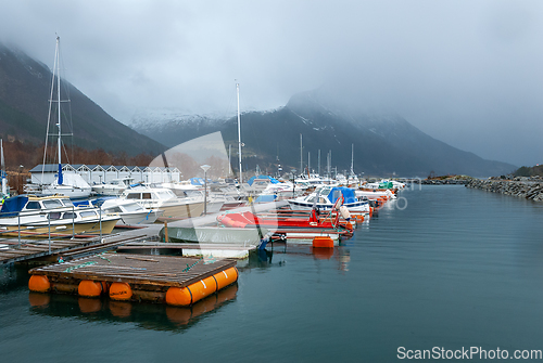 Image of boats in marina with sun through cloud cover