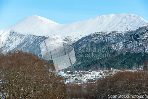 Image of snowy mountains above small town