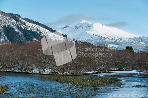 Image of snow-covered mountains and river in the foreground