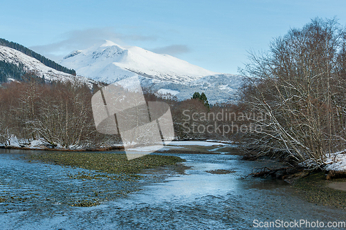 Image of snow-covered mountains and river in the foreground