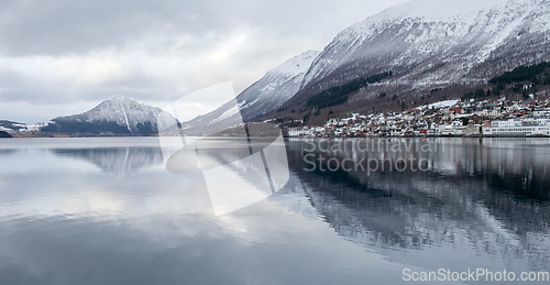Image of mountains reflected in water and small town