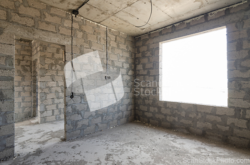 Image of Construction of an individual residential building, view of two walls, interior with a doorway and exterior with a window opening