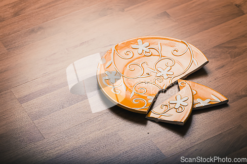 Image of Broken ceramic plate on wooden floor