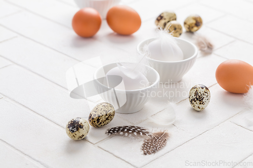 Image of Different eggs with feathers for Easter on white background