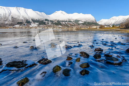 Image of frozen sea with rocks sticking out of the ice with ørsta and ni