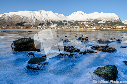 Image of frozen sea with rocks sticking out of the ice with ørsta and ni