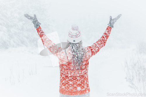 Image of Woman out in the forest with heavy snow falling