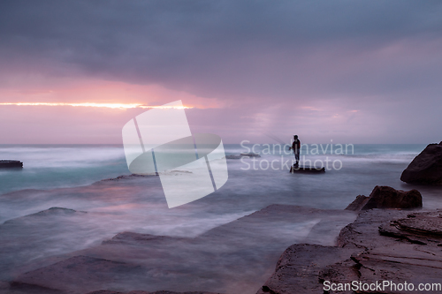 Image of Stormy coast with a glimpse of sunrise through clouds