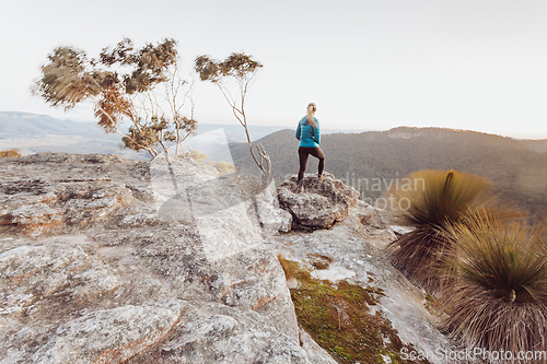 Image of Female hiker looking out over views from high cliffs to valleys