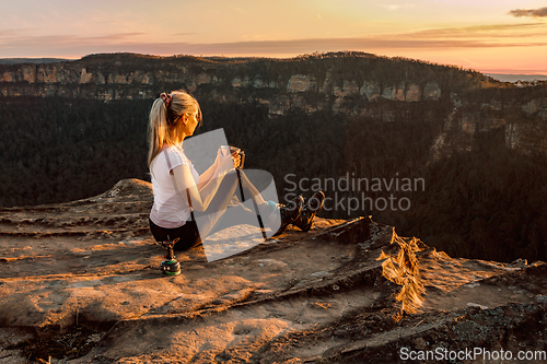 Image of Girl is watching sunsets on cliff tops