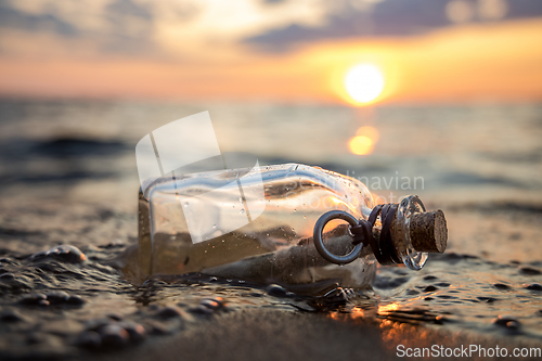 Image of Message in the bottle against the Sun setting down