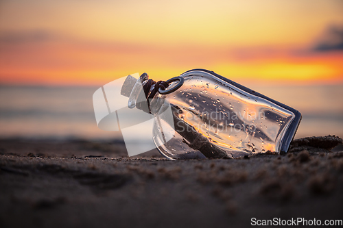 Image of Message in the bottle against the Sun setting down