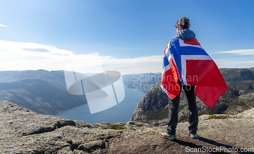 Image of Woman with a waving flag of Norway on the background of nature