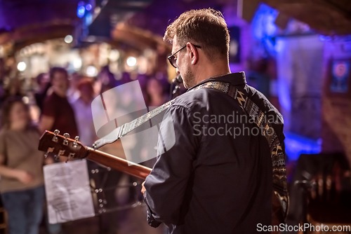 Image of Band performs on stage, rock music concert.