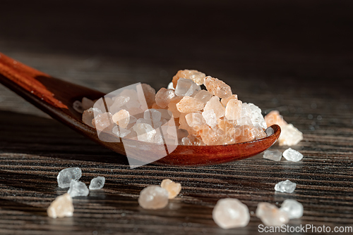 Image of Himalayan pink salt in a wooden is used to flavor food.