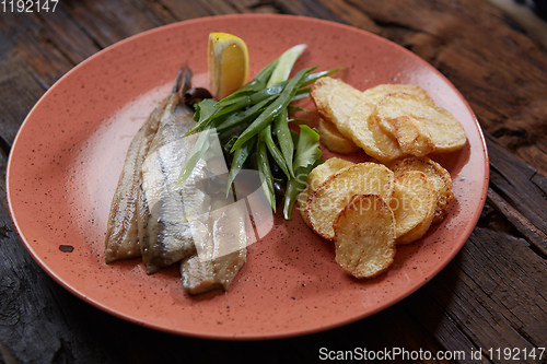 Image of Pacific herring with fried potatoes and onion