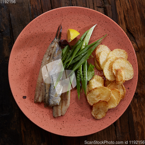 Image of Pacific herring with fried potatoes and onion