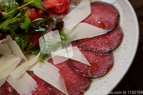 Image of The carpaccio with cheese and salad top view