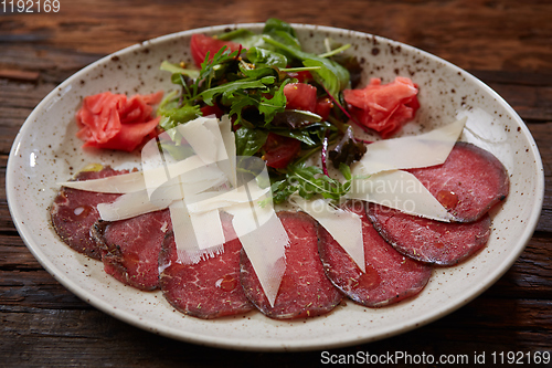 Image of The carpaccio with cheese and salad top view
