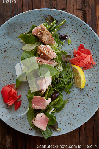 Image of beautiful food: steak tuna in sesame, lime and fresh salad close-up on a plate on the table.