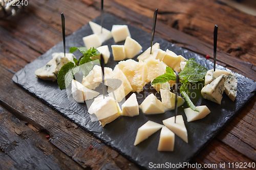 Image of Cheeseboard Top View on Black Stone Plate Background