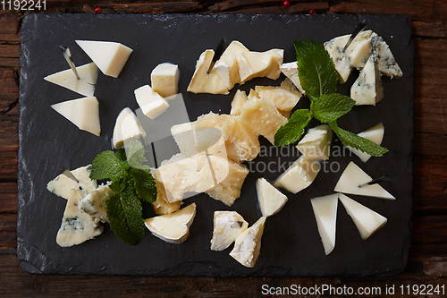 Image of Cheeseboard Top View on Black Stone Plate Background