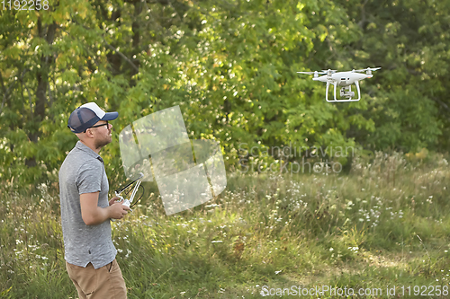 Image of Man manages quadrocopters. Remote control for the drone in the hands of men. Unmanned aerial vehicle