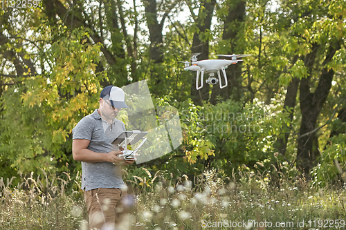 Image of Man manages quadrocopters. Remote control for the drone in the hands of men. Unmanned aerial vehicle