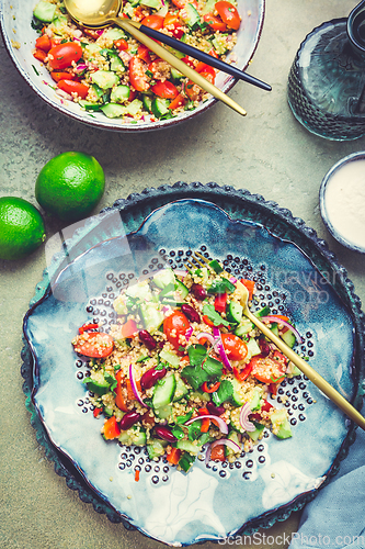 Image of Healthy quinoa black bean salad with fresh tomatoes, cucumbers, onion and cilantro