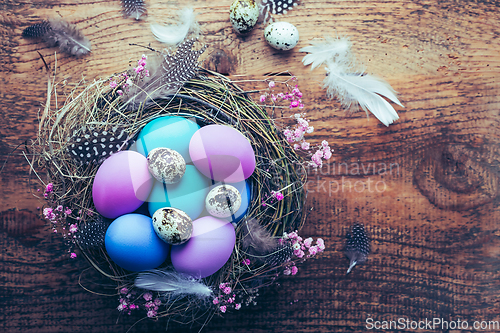 Image of Happy Easter - nest with Easter eggs on wooden background with copy space