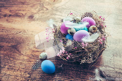 Image of Happy Easter - nest with Easter eggs on wooden background with copy space