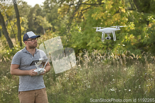 Image of Man manages quadrocopters. Remote control for the drone in the hands of men. Unmanned aerial vehicle