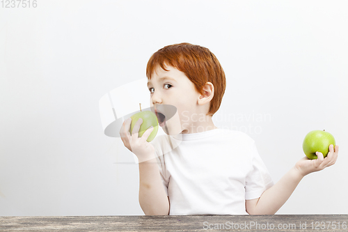 Image of boy holds green apple