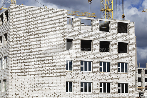 Image of construction cranes and brick building