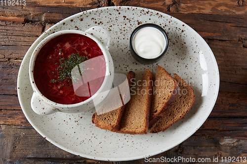 Image of Traditional Ukrainian Russian borscht with white beans on the bowl. Plate of red beet root soup borsch on black rustick table. Beetroot soup Top view. Traditional Ukraine food cuisine