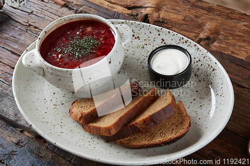 Image of Traditional Ukrainian Russian borscht with white beans on the bowl. Plate of red beet root soup borsch on black rustick table. Beetroot soup Top view. Traditional Ukraine food cuisine