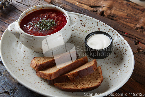 Image of Traditional Ukrainian Russian borscht with white beans on the bowl. Plate of red beet root soup borsch on black rustick table. Beetroot soup Top view. Traditional Ukraine food cuisine