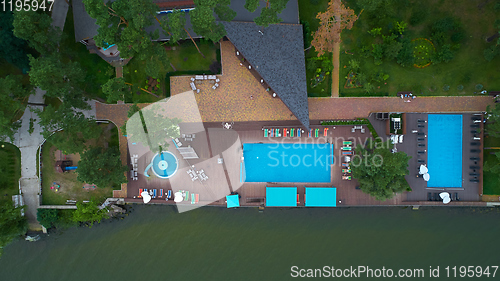 Image of Aerial view of luxury house garden with swimming pool surrounded by trees.