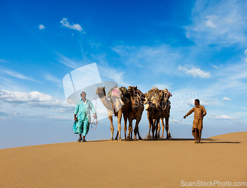 Image of Two cameleers (camel drivers) with camels in dunes of Thar deser