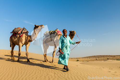 Image of Cameleer (camel driver) with camels in dunes of Thar desert. Raj