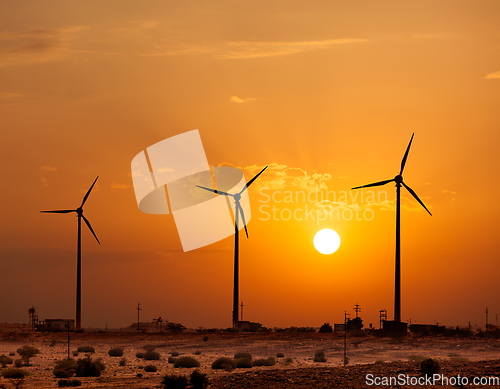 Image of Wind generator turbines sihouettes on sunset